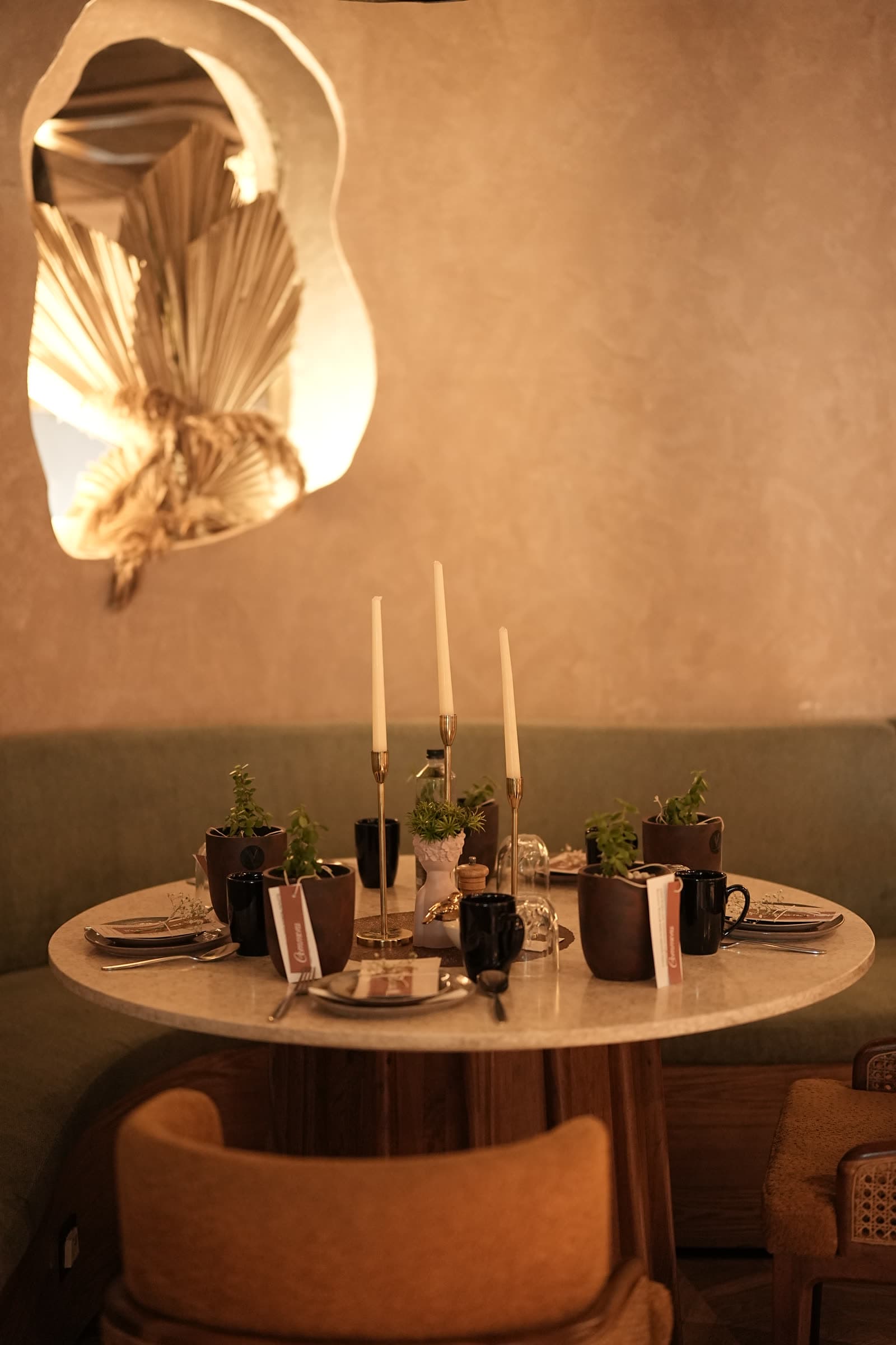 A candlelit round table set for a Commons dinner.